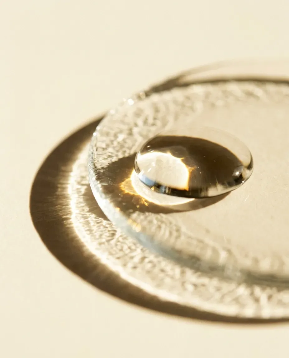 Single clear droplet resting on a glass dish