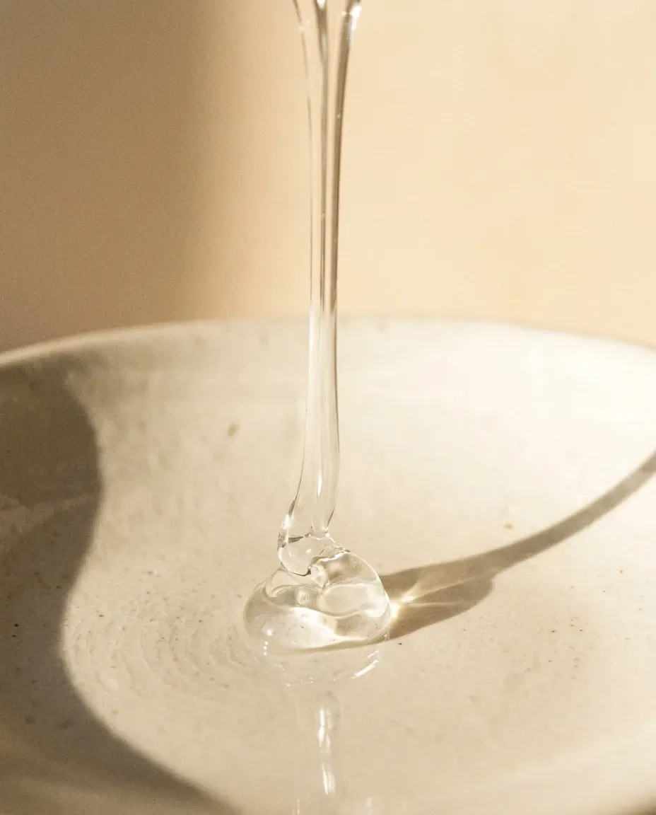 Thick, clear stream of gel pouring onto a ceramic dish